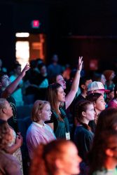 A vibrant youth group engaged in worship during a church service in Elk Grove.