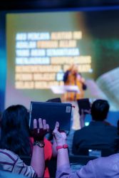 Attendees raise Bibles at a vibrant worship event in Jakarta, Indonesia.