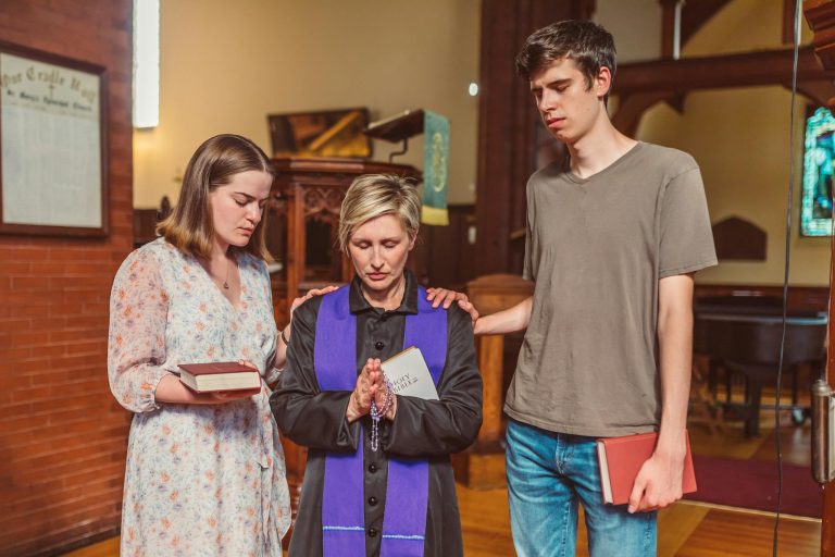 Group of people praying in a church setting, showcasing faith and spirituality.